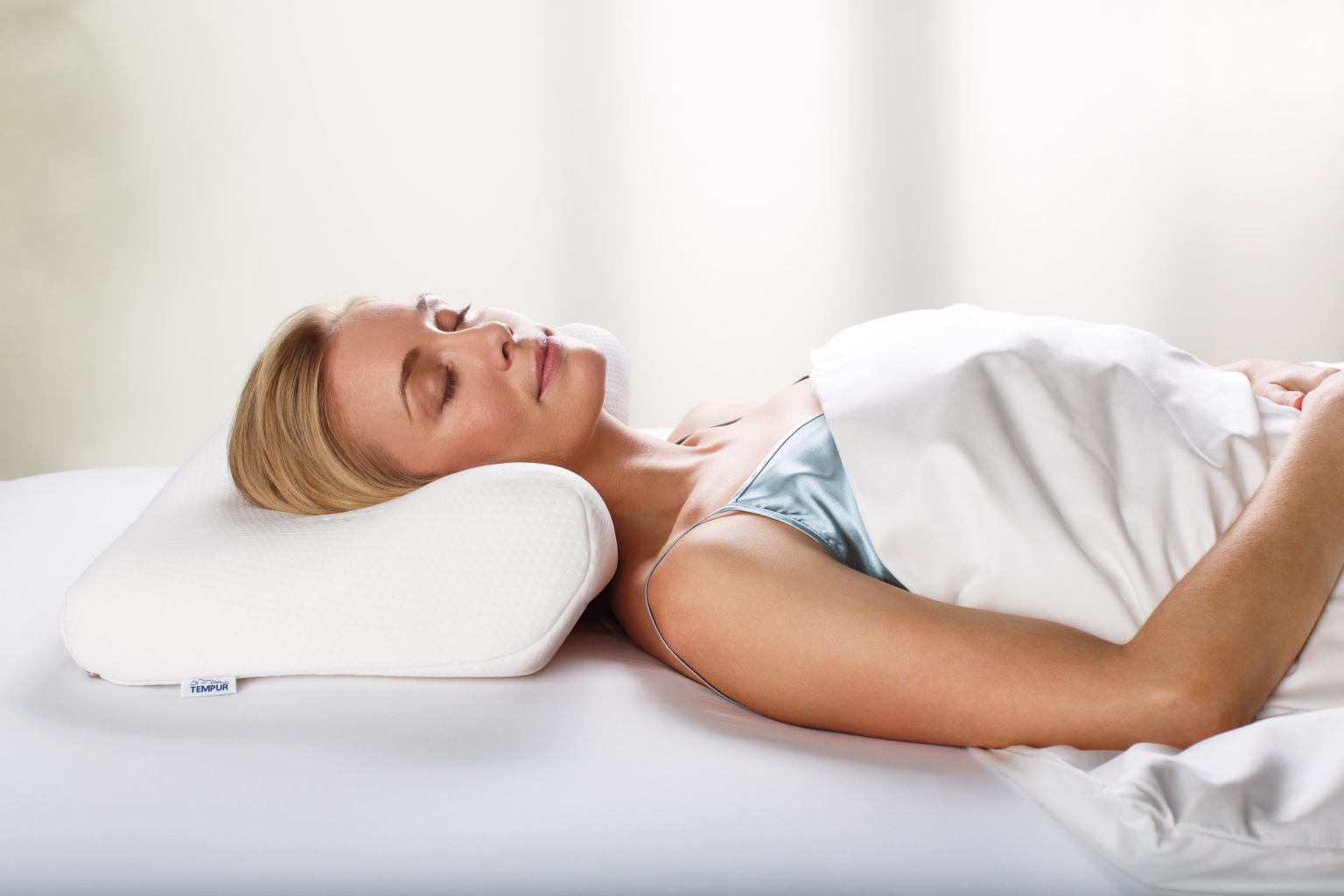 TEMPUR_Millennium_Ergonomic_Pillow_with_model_2015-min-1536x1024 Какую пользу здоровью обеспечивает ортопедическая подушка?